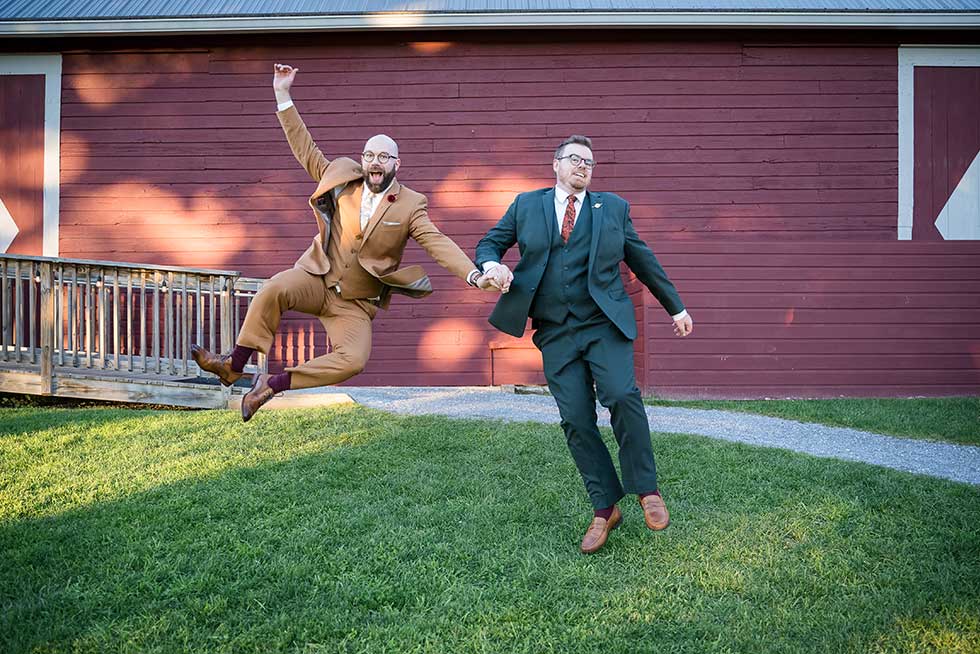 fun photo of groom and groomsman jumping