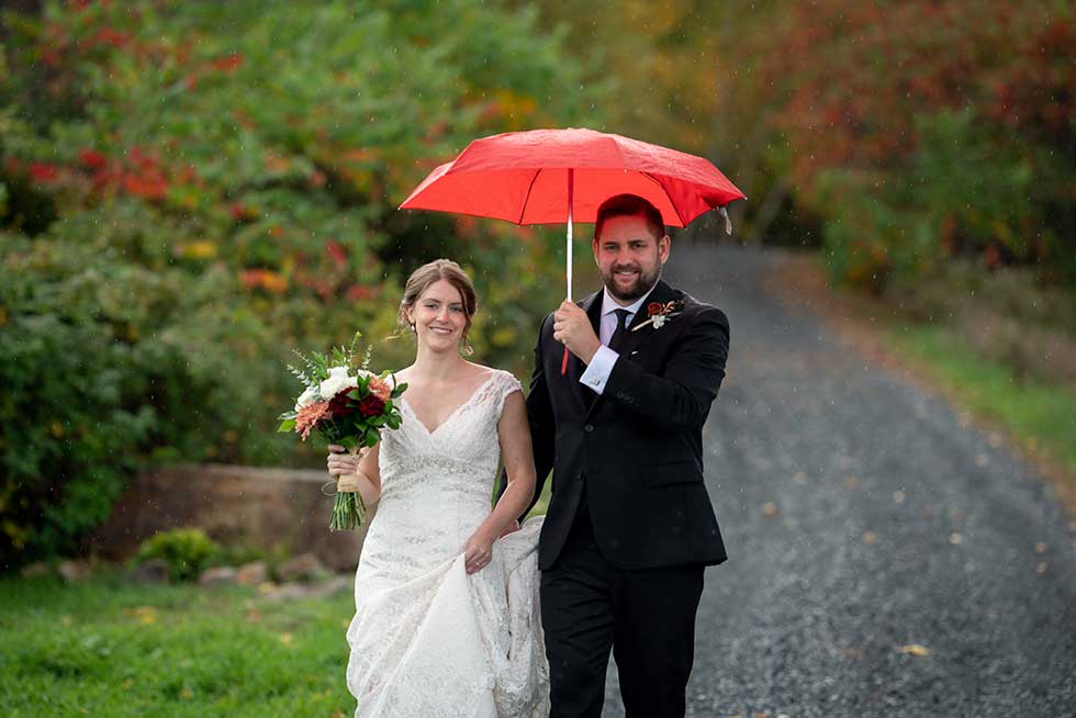 wedding photo in rain with umbrella
