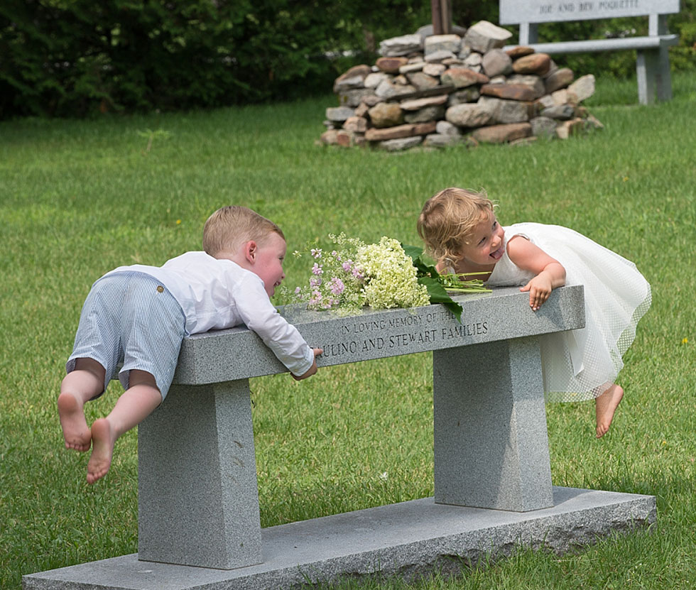 2 kids playing on bench at wedding