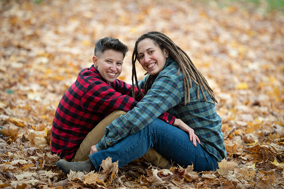 Engaged couple posing wearing flannel