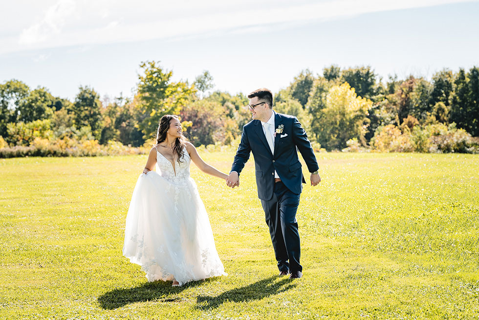 wedding couple running in field